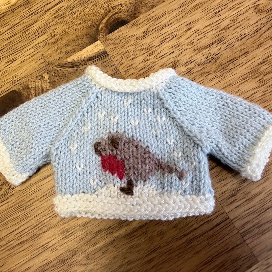 Tiny blue Little Cotton Rabbit Christmas jumper knitted by Mandy, with a white collar and cuffs and a robin on the front.